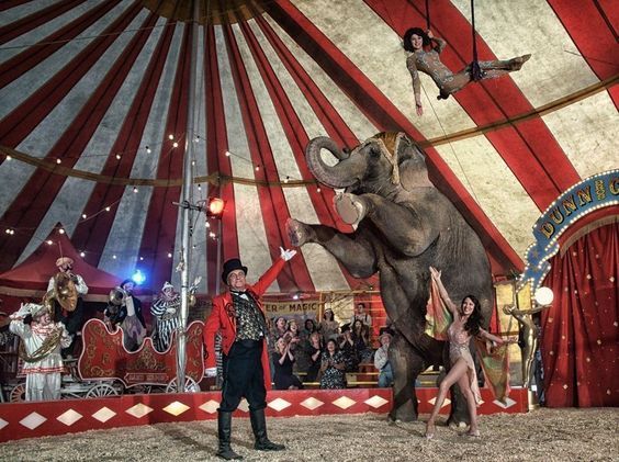 Geçmişten bir sirk topluluğu, karavan ve kostümleriyle sokakta performans hazırlığında